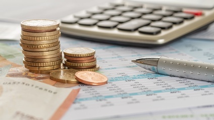 Taschenrechner, Stift und Münzen