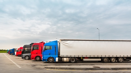 Hintereinander parkende Lkws unter bewölktem Himmel