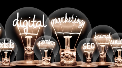 Leuchtende Glühbirnen mit Schriftzügen im Inneren zum Themenfeld Digital Marketing