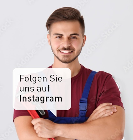Ein junger Installateur mit verschränken Armen und einem Schraubenschlüssel in der Hand