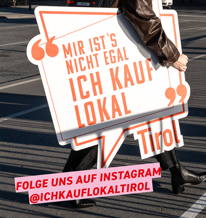 Eine Person hat einen Karton in der Hand mit der Aufschrift 