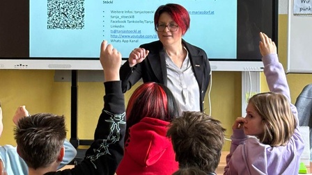 Frau vor Schülern mit erhobenen Händen