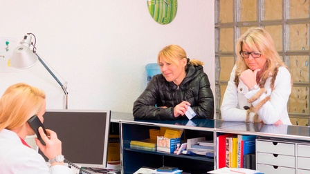 Zwei Personen warten in einer Azrtpraxis