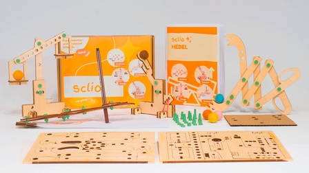 Blick auf die Hebel-Box mit ihren Inhalten, z.B. ein Holzkatapult und ein Büchlein