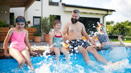 Vater und Kinder haben Spaß im Pool