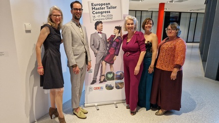 Gruppe vor Plakat EMTC 2026