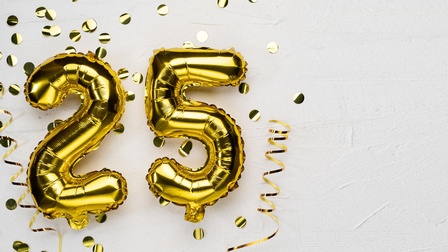 Auf hellem Hintergrund sind in der linken Bildhälfte Luftballons in denen Formen einer zwei und einer fünf. Daneben ist goldenes Konfetti