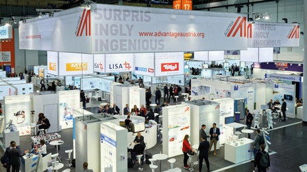 Blick auf einen ADVANTAGE AUSTRIA-Messestand von oben mit Aussteller:innen und Kund:innen<br />
