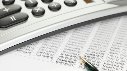 Ein Taschenrechner - darunter Zahlenkolonnen und ein Kugelschreiber