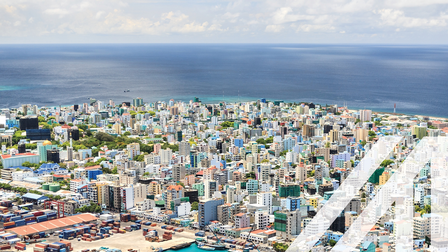 Blick auf den Hafen und die bunte Stadt Male, Hauptstadt der Malediven, mit vielen Hochhäusern vor dem tiefblauen Ozean