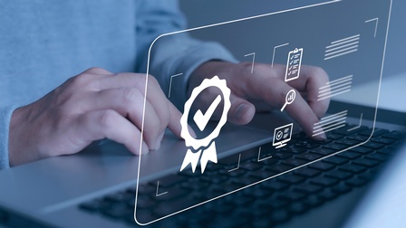 Hände auf einem Laptop - darüber Zertifizierungssymbole