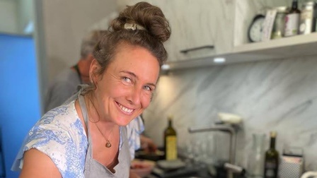 Eine lächelnde Frau, die gerade kocht.