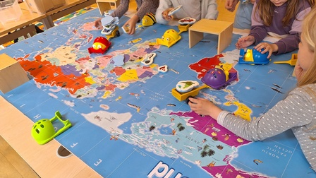 Eine bunte Spielstation mit darauf spielenden Kindern.