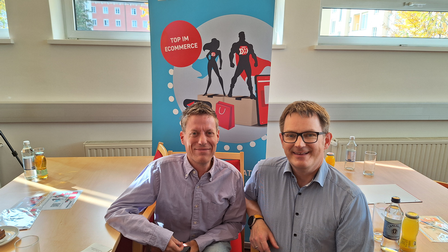 zwei männer vor einem rollup der wko onlinehelden