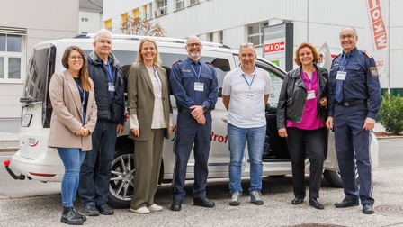 Gruppenfoto vor einem Fahrschulauto