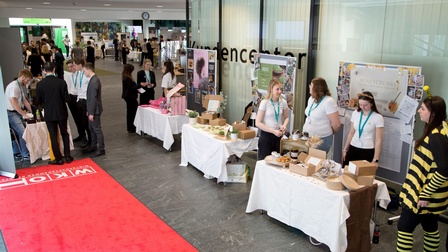 Blick in den Eingagnsbereich der Wirtschaftskammer Kärnten mit aufgebauten Ständen der Schüler:innen, an denen sie ihre Unternehmen präsentieren
