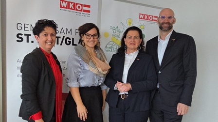 Drei Frauen und ein Mann vor zwei Roll-ups