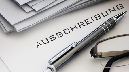 Ausschreibungsmappen und Kugelschreiber sowie Brille