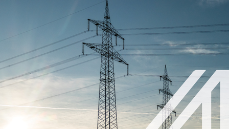 Strommasten unter leicht bewölktem aber blauen Himmel