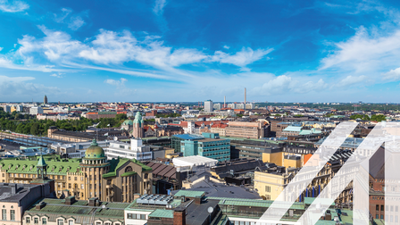 Stadtansicht von Helsinki mit modernen und historischen Gebäuden unter blauem Himmel mit einigen Wolken. Über das Bild wurde ein weißes Austria A gelegt.