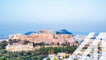 Blick auf die Stadt Athen mit dem Akropolis-Berg, umrandet von Bäumen. Über das Bild wurde ein weißes Austria A gelegt.