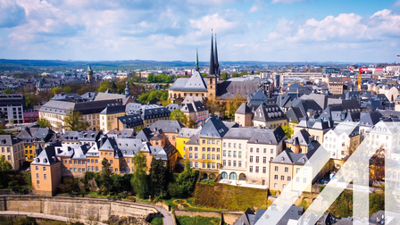 Blick von oben auf die historischen Gebäude in der Stadt Luxemburg, in der Mitte erkennt man eine Kirche 
