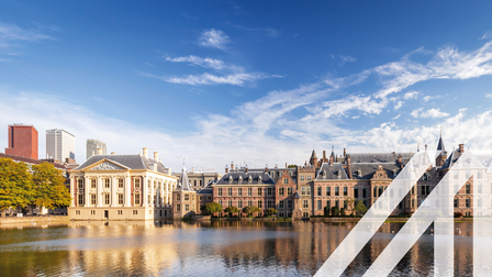 Blick auf den Binnenhof, das niederländische Parlament in Den Haag, historische Häuser gelegen am Wasser unter blauem Himmel. Über das Bild wurde ein weißes Austria A gelegt.
