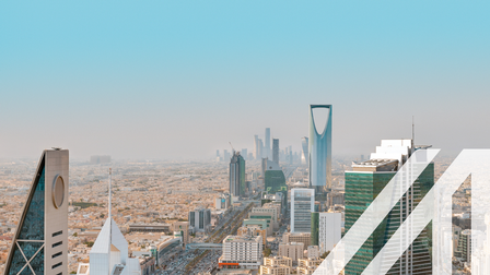 Blick auf die Skyline von Saudi Arabiens Hauptstadt Riyadh mit seinen modernen Wolkenkratzern und einer belebten Straße.
