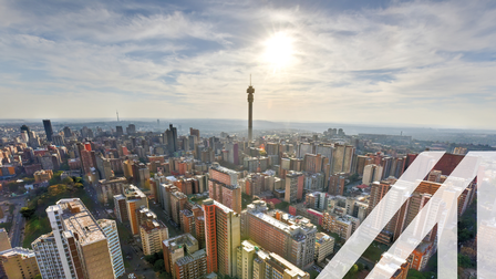 Stadtansicht von Johannesburg: Blick von oben auf zahlreiche bunte Wolkenkratzer, darunter der Hillbrow Tower in der Hauptstadt von Südafrika