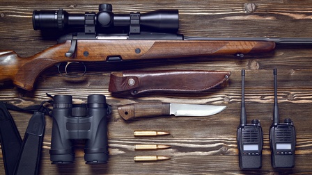 Verschiedene Jagdwaffen auf einem Holztisch
