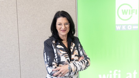 Portrait von Maria Neumann vor Wand mit WIFI-Logo