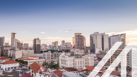 Blick auf Luanda, Hauptstadt von Agola. Man sieht im Vordergrund historische weiße Häuser mit roten Dächern, im Hintergrund Wolkenkratzer.