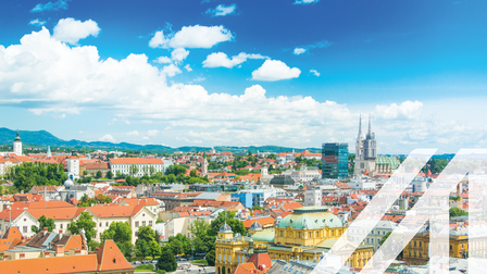 Panoramablick auf die roten Dächer der historischen Häuser im Zentrum von Zagreb mit der katholischen Kathedrale, der Himmel mit einigen Wolken ist blau