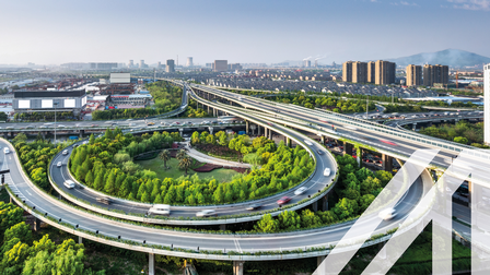 Verkehr auf einer erhöhten Stadtautobahn umgeben von Bäumen und Wolkenkratzern