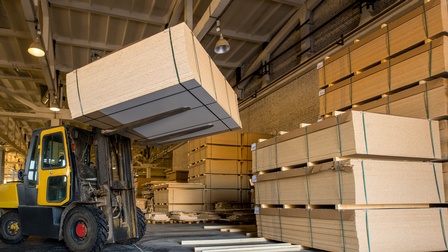 Gabelstapler mit Holzplatten in einer Lagerhalle