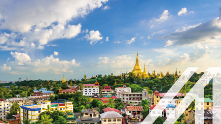 Blick auf Yangon, Hauptstadt von Myanmar. Bunte Häuser und grüne Wälder im Vorderund, im Hintergrund eine goldene Pagode 