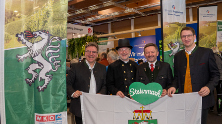 Vier Männer posieren neben einem Rollup und einem grünen Steiermark Herz bei den Steirerstundn