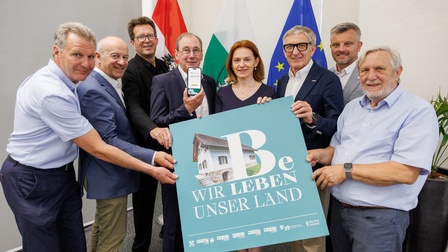 8 Personen halten ein Schild mit der Aufschrift 