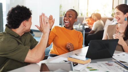Drei lachende Personen mit High Five