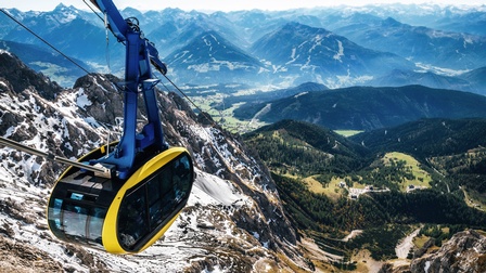 gelbe futuristische Seilbahngondel vor Bergpanorama am Dachstein