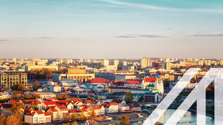 Blick auf  die historische Altstadt von Minsk, Hauptstadt von Belarus; weiße Häsuer mit roten Dächern und Fluß im Vordergrund