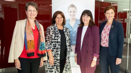 Frauen stehen lächelnd nebeneinander