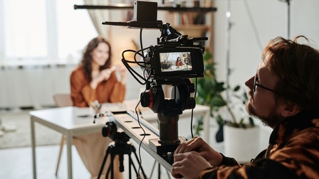 Eine Frau wird von einem Kameramann gefilmt