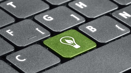 Computertastatur mit einer grünen Taste mit einem Glühbirnensymbol