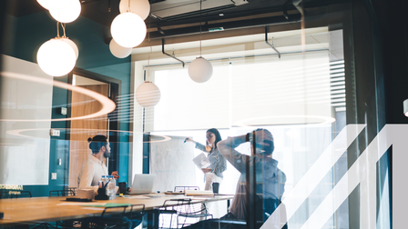 Geschäftsleute arbeiten mit Whiteboard und Dokumenten im Konferenzraum.