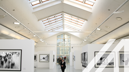 Schwarz-Weiß-Fotoausstellung in einer weißen Galerie mit Deckenfenstern