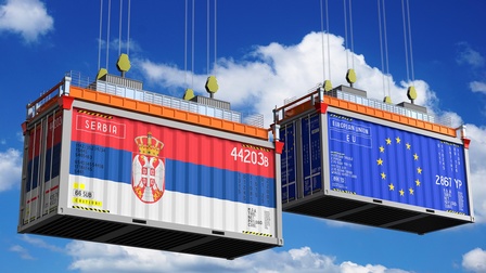 Zwei Container - einer trägt die Flagge der EU, der andere die Flagge Serbiens