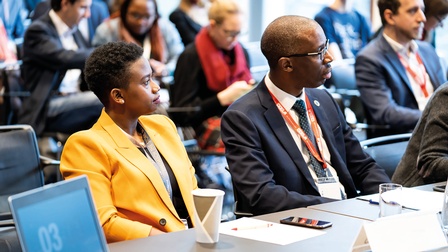 Gemischtes vor einem Tisch sitzendes Publikum bei einem Vortrag<br />
