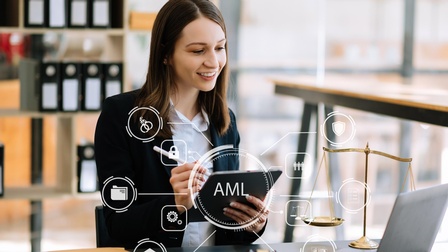 Eine Person sitzt an einem Tisch. In den Händen hält sie ein Tablet. Vor ihr ist ein aufgeklappter Laptop. Overlay diverser Symbole: Über der Person in der Mitte steht AML. Um AML sind verschiedene Symbole angelegt wie Zahnräder, eine Waage, ein Schloss.