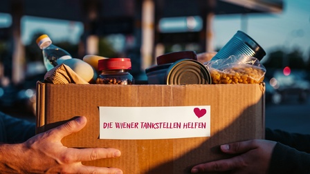 Hände halten eine Box voll mit Lebensmitteln